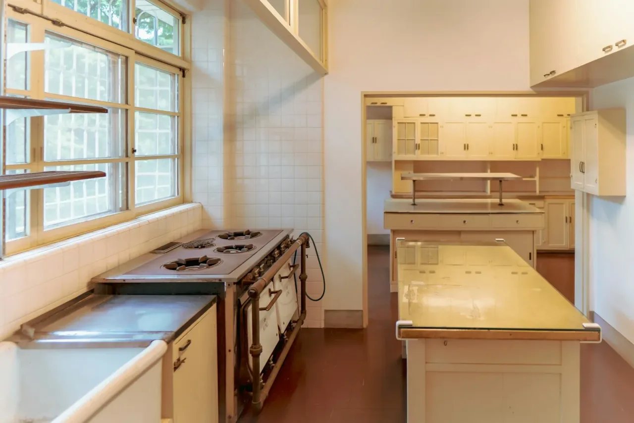 Kitchen before remodel — dated cream cabinetry and vintage range
