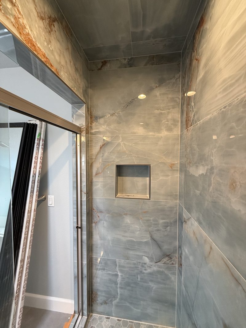 Blue-veined marble walk-in shower with niche and integrated bench