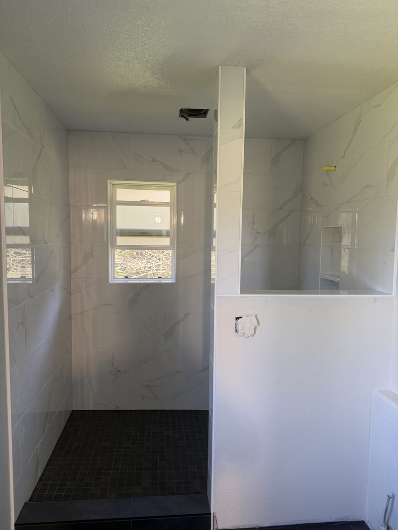 White marble shower with daylight window and curbless entry