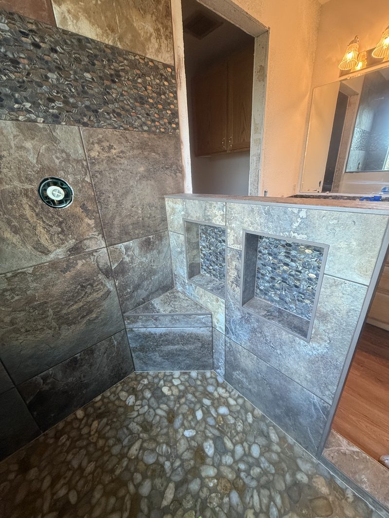 Slate stone walk-in shower with river-rock floor and double niche