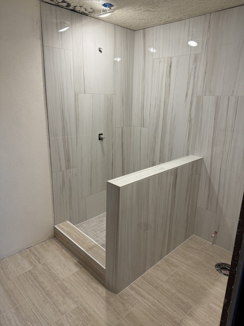 Walk-in shower with floor-to-ceiling zebra-stripe marble panels